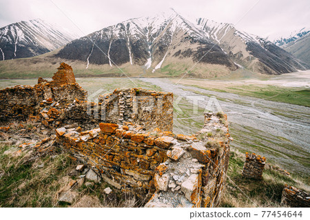 Fortress On Mountain Background Near Karatkau Village, Kazbegi District, Mtskheta-Mtianeti Region, Georgia. Spring, Summer Season. Truso Gorge. Fortress On Mountain Background Near Karatkau Village, Kazbegi District, Mtskheta-Mtianeti Region, Georgia. Spring, Summer Season. Truso Gorge. 77454644