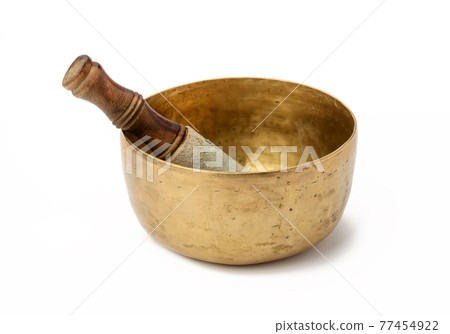 copper singing bowl and wooden clapper on a white background. Musical instrument for meditation, relaxation, various medical practices related to biorhythms copper singing bowl and wooden clapper on a white background. Musical instrument for meditation, relaxation, various medical practices related to biorhythms 77454922