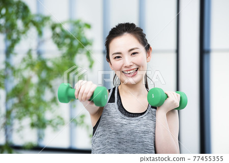 Young women sportswear looking at the camera dumbbell punch Young women sportswear looking at the camera dumbbell punch 77455355