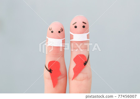 Fingers art of couple in medical mask from COVID-2019. Concept of couple holding broken heart. Fingers art of couple in medical mask from COVID-2019. Concept of couple holding broken heart. 77456007