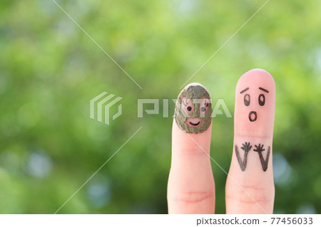 Fingers art of couple. Husband saw his wife with clay face mask and was afraid. Fingers art of couple. Husband saw his wife with clay face mask and was afraid. 77456033