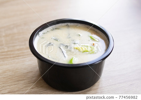 Cheese soup in black bowl on wooden table Cheese soup in black bowl on wooden table 77456982