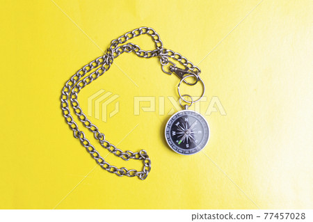 Compass with chain on a yellow background 77457028