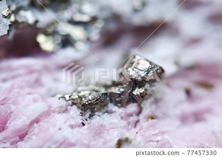 Pink crystals Rhodochrosite with particles of Pyrite. Natural  texture of mineral for background. Beautiful background and wallpaper. Macro. 77457330