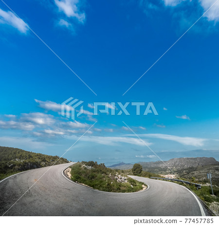 U-shape mountain road under clear blue sky U-shape mountain road under clear blue sky 77457785