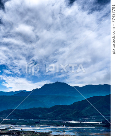 Flooded rice fields, mountains, antenna and cloudscape Flooded rice fields, mountains, antenna and cloudscape 77457791