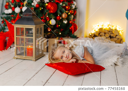 Beautiful little girl lies on the floor by the 77458168