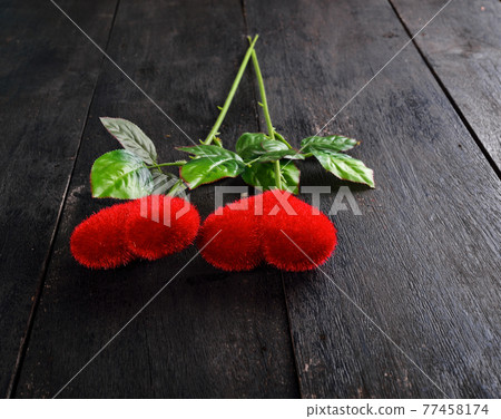 A red heart on a black background. 77458174
