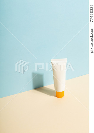 White tube of sunscreen on  blue background. Sun Protection. Copy space 77458325