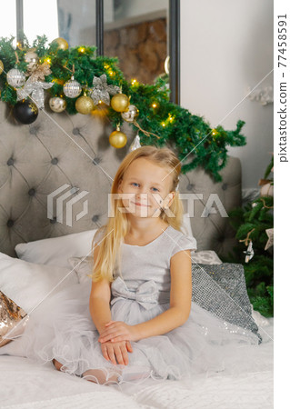 Beautiful little girl sitting on the New Year's 77458591