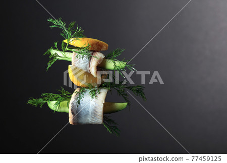 Herring fillet in oil with lemon, cucumber, and dill. 77459125