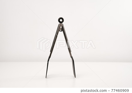 black Kitchen tongs on a white background. 77460909