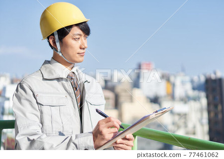 A young man wearing work clothes 77461062