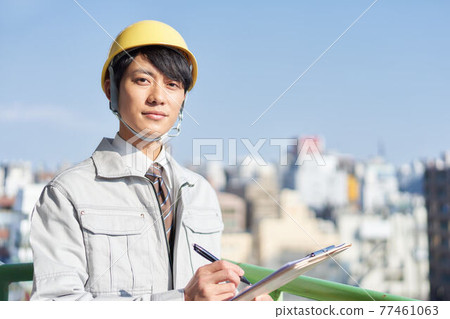 A young man wearing work clothes 77461063