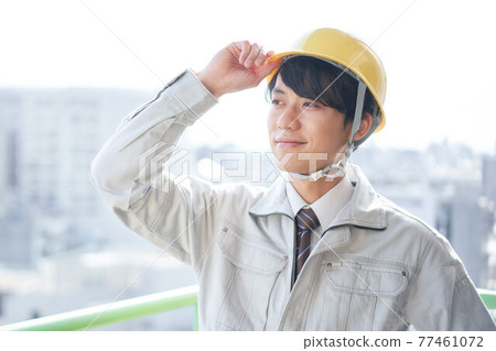 Men in work clothes putting their hands on the helmet 77461072