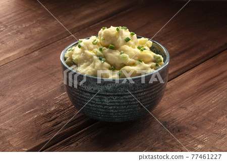 Pomme puree, a photo of a bowl of mashed potatoes with herbs on a dark rustic background 77461227