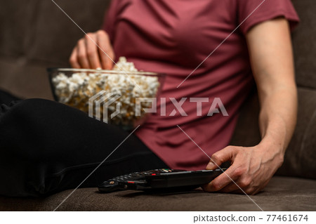 remote control and popcorn when watching a movie and broadcasting remote control and popcorn when watching a movie and broadcasting 77461674