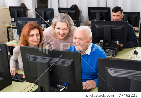 Elderly people working together on computer 77462225