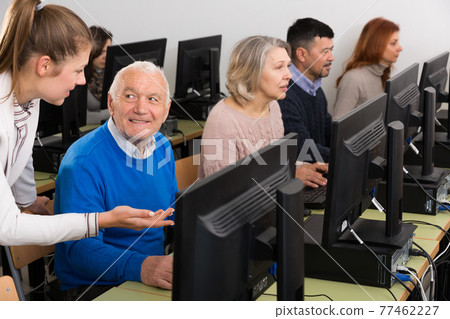 Serious business woman helping to male partner, pointing at computer monitor 77462227