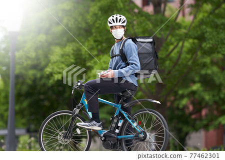 一個戴口罩騎自行車的送貨員 77462301