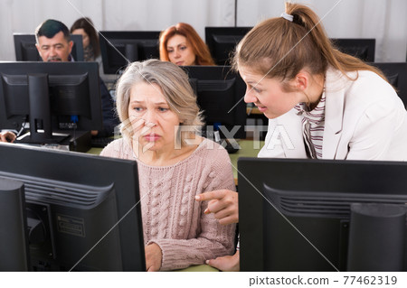 Focused mature woman taking computer lessons 77462319