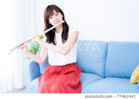在沙發上吹長笛的女人 77462445