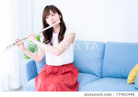在沙發上吹長笛的女人 77462446