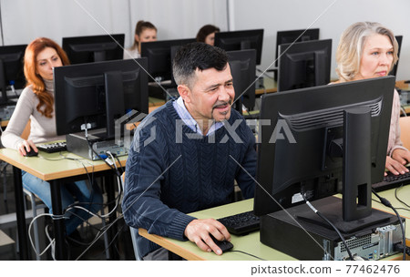 Middle aged man taking computer lessons 77462476