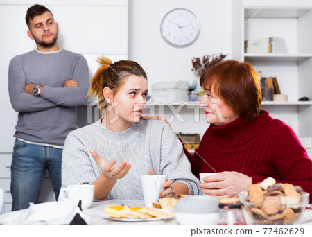 Woman asking upset girl to forgive son after quarrel 77462629