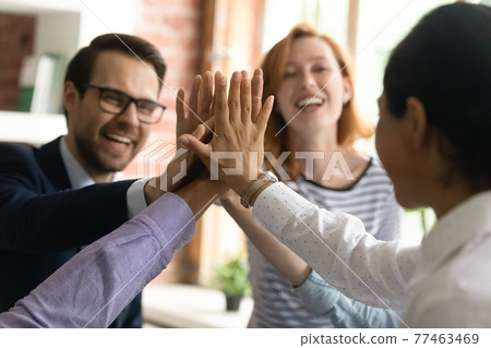 Close up diverse employees team giving high five, celebrating success Close up diverse employees team giving high five, celebrating success 77463469