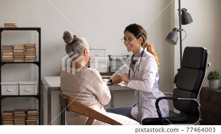 Happy woman medic inform senior female patient about positive dynamics 77464003