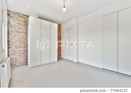 Wardrobe near windows and brick wall 77464237