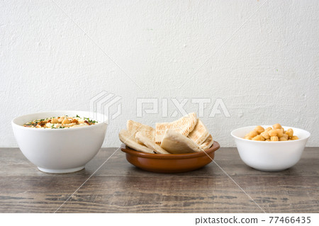 Hummus on a rustic wooden table 77466435