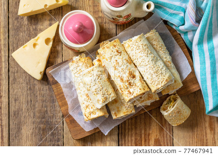 Breakfast, picnic, lunch or snack concept. Lavash roll with cottage cheese, cheese and spinach on a rustic table. Top view, flat lay. Breakfast, picnic, lunch or snack concept. Lavash roll with cottage cheese, cheese and spinach on a rustic table. Top view, flat lay. 77467941
