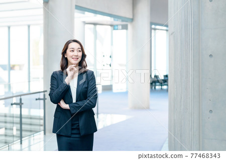 一套衣服的女商人拜訪智能手機在辦公室 77468343