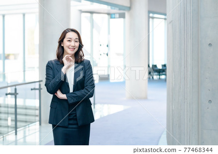 一套衣服的女商人拜訪智能手機在辦公室 一套衣服的女商人拜訪智能手機在辦公室 77468344