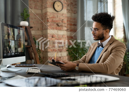 Video conferencing with colleagues on computer 77469060