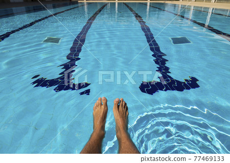 The feet of a young man in a swimming pool in summer, Spain. The feet of a young man in a swimming pool in summer, Spain. 77469133