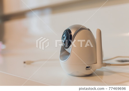 Baby monitor and toy on table in room, space for text. CCTV equipment. 77469696