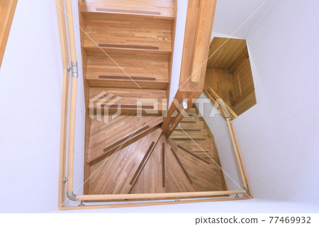 A white wall with a handrail on the stairs that goes up to the second floor in a wooden house A white wall with a handrail on the stairs that goes up to the second floor in a wooden house 77469932