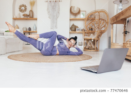 Fitness woman working out at home doing twists abs exercises 77470646