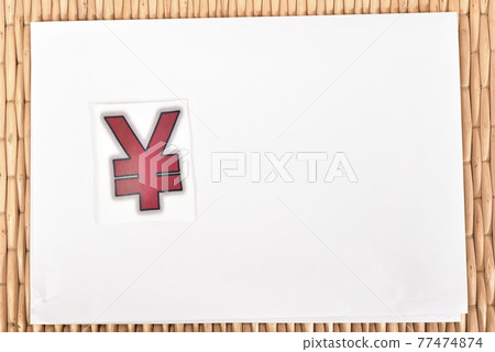 A whiteboard with a yen sign and a wicker suitcase 77474874