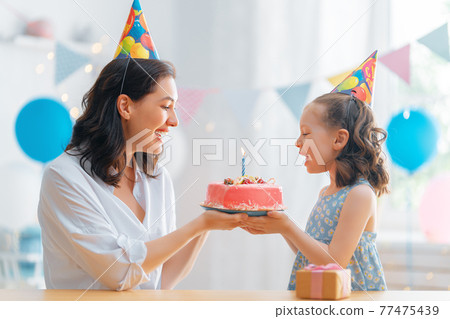 Mother and daughter are celebrating birthday. 77475439