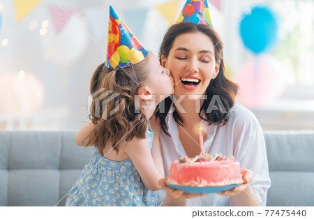 Mother and daughter are celebrating birthday. 77475440