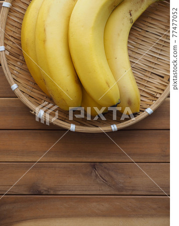 Yellow bananas in a basket, tropical fruit 77477052