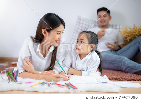 Young family drawing together with colorful pencils at home Young family drawing together with colorful pencils at home 77477386