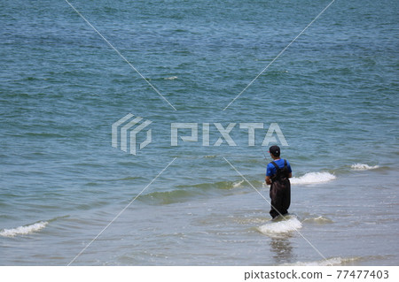 Behind a boy enjoying sea fishing 77477403