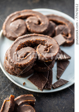 Sweet pastry palmeritas with chocolate icing. Sweet pastry palmeritas with chocolate icing. 77478012