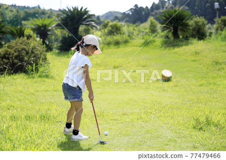 Infant (5 years old) playing putter golf 77479466