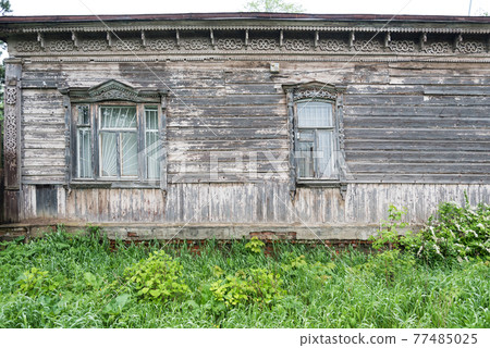 A very old house made of wood. Window with carved platbands. Background, texture. There is space for text. 77485025